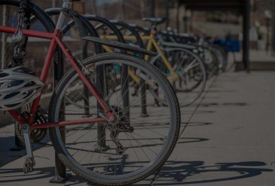 bicycles showing rear wheel  locked and parked at the bicycle rack in a row during day time